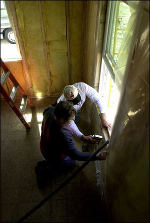 Bob Keller, front, and Dan Weirich work on the Habitat for Humanity house on Woodmore Street in Northwood.