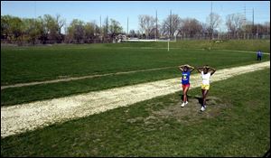 Libbey s Peggy Moore, left, and Danyelle McGary cool down after a sprinting on Libbey s old track. Four other Toledo public schools face the same dilemma.