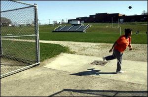 Nicole Crowell practices a toss at
Libbey. The discus/shot put practice area is a cement spot
near a drain next to the football field.
