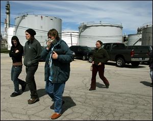Ohio Citizen Action members, one wearing a gas mask, enter the Sunoco refinery property.