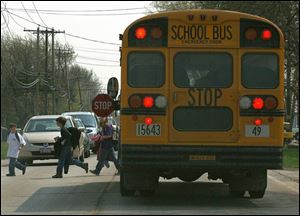 Flashing lights and an extended stop sign are the signals for traffic to stop so children can safely cross the road after exiting an Oregon school bus.