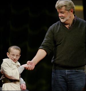 'Star Wars' creator George Lucas, right, greets 8-year-old Tyler Hamrick of Glen Burnie, Md.