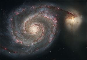 The new Whirlpool Galaxy image showcases the spiral galaxy's classic features, from its curving arms, where newborn stars reside, to its yellowish central core that serves as home for older stars.  The soaring tower is 9.5 light-years or about 90 trillion kilometers high, about twice the distance from our Sun to the next nearest star. A torrent of ultraviolet light from a band of massive, hot, young stars [near the top] is eroding the pillar. The dominant colors in the image were produced by gas energized by the star cluster's powerful ultraviolet light. The blue color at the top is from glowing oxygen. The red color in the lower region is from glowing hydrogen. 