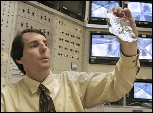Mr. Murphy examines a section of the solar sail. ATK is one of two solar sail companies competing to win NASA's favor.