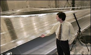 Dave Murphy, principal investigator for ATK Space Systems, ripples the surface of a solar sail panel at the NASA Glenn Research Center's Plum Brook Station in Sandusky. 