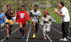 Bowsher track coach Mark Coe puts his runners
through a workout including, from left, Chanelle Caldwell, MeShawn Graham, Alisha Jones and Tasha Banks. The Rebels are increasing their speeds by working hard on the track and in the weight room.