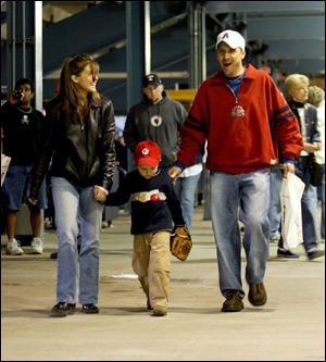 FEA first16p     Andrew Surgo, center, walks with his parents Lisa and Todd during the Mud Hens game Saturday evening 4/16/05.  The Blade/Madalyn Ruggiero