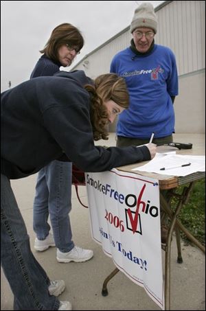 Marilyn Wagoner, foreground, signs a Smoke Free Ohio petition as her mother waits. Manning the table outside the Lucas County Recreation Center is Stu Kerr, Smoke Free Ohio regional volunteer coordinator.