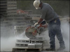 BIZ build15p C -- Bill Sattler of Spartan Construction cuts concrete blocks where a new strip mall will house nine businesses, Wednesday, 05/11/05. The Blade/Andy Morrison