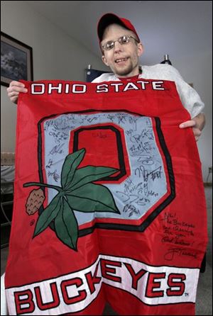 Neil Shuff shows off the banner that was signed by Jim Tressel and many Ohio State players. 