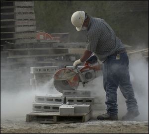 BIZ build15p C -- Bill Sattler of Spartan Construction cuts concrete blocks where a new strip mall will house nine businesses, Wednesday, 05/11/05. The Blade/Andy Morrison