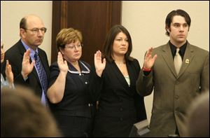 David, left, Laurie, Kathryn, and Kevin Kilpatrick are administered the oath of citizenship. The
former Canadians were planning to celebrate their citizenship by drinking Canadian beer.