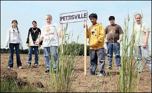 From left, Bethany Iott, Krysta Spiess, Torin Blosser, Jacob Valdez, Victor Garcia, and Stephanie Hamilton hold up their town's sign at the site where MapQuest and the government indicate the town is located. It is not the right location.
