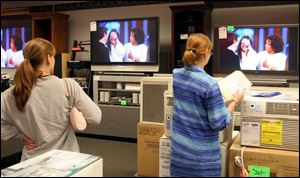 Alison Ogdahl of Rossford interrupts her shopping at Appliance Center in Maumee to watch Tom Cruise and Katie
Holmes on Oprah yesterday afternoon.