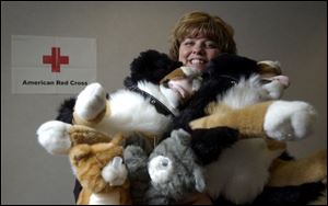Lynn Curtis of the Toledo Red Cross holds some of the stuffed animals used in the class her organization will offer next month through Owens Community College.