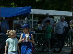 NBR springp21 06 -- Mary Miller, 6, and Nicholas Jones, 9, walk through a festival organized by the Delta Chamber of Commerce on Saturday. The festival included bedding plants, handmade crafts, contests, food vendors and activities for children. The Blade/Alyssa Schukar