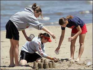 ROV sandcastle 02 - L-R, Mattie Smith, Danie Smith, Emily Bodart, all seniors at Hopewell-Loudon HS in Bascom, OH take a day off at the beach together before Friday's graduation and they all part ways of college. The Blade/Allan Detrich