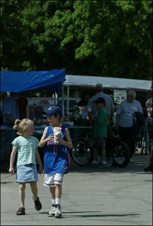 NBR springp21 06 -- Mary Miller, 6, and Nicholas Jones, 9, walk through a festival organized by the Delta Chamber of Commerce on Saturday. The festival included bedding plants, handmade crafts, contests, food vendors and activities for children. The Blade/Alyssa Schukar