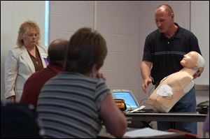 Larry Armstrong uses a mannequin to demonstrate resuscitation equipment during a class at the daylong seminar.