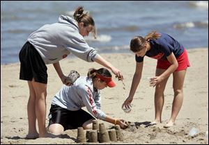 ROV sandcastle 02 - L-R, Mattie Smith, Danie Smith, Emily Bodart, all seniors at Hopewell-Loudon HS in Bascom, OH take a day off at the beach together before Friday's graduation and they all part ways of college. The Blade/Allan Detrich