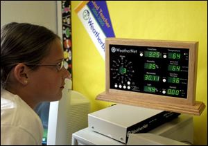 Nine-year-old Justine Tolles checks out the figures on the WeatherNet at Weston Elementary school. A grant paid $6,211 to have the equipment installed.