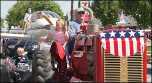 Cty WalRally21p 5 .jpg John Schramm drives tractor pulling plane as his grand daughter Sarah Asburger tosses candy.   blade photo by herral long 5/21/2005