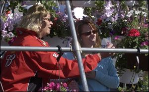 Amy Leonard, left, and Sylvia Kachar check out hanging baskets at the Toledo Farmers Market Flower Day sale. The annual event, which showcases area floriculture, draws tens of thousands of people. Ohio is a top producer of bedding plants. 