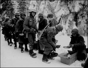 Pfc. John Chavez is fourth in line for a meal. He believes the photo was taken during the Vosges Mountains compaign, probably near Lichtenberg, France.