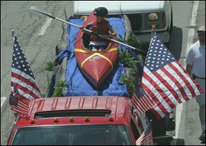 Zack Kurtz rides a kayak on the Calvary Assembly of God bible school float in the Memorial Day parade in downtown Toledo. 