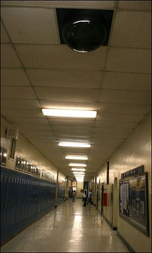 A hallway at Jones Junior High School is monitored by a ceiling-mounted video camera housed in a plexiglass bubble. The school is equipped with eight surveillance cameras.