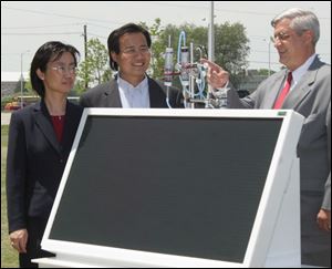 Liwei Xu, Xunming Deng, and Stanley Rubini examine the business end of a solar hydrogen generator. 