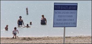 In summers past, some bathers ignore water-quality advisory signs like the one posted at Maumee Bay State Park.