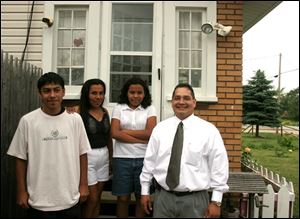 Maria Espinoza, second from left, gathers with Antonio, 14, Eva, 12, and agent Frank Smith at her home in Northwood. 