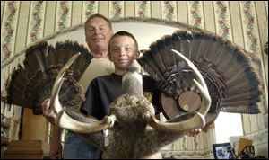 Bill Reynolds of Elmore and his son, Brad, 13, display the two turkey tails and a buck that the teenager was fortunate to bag while hunting and sharing time outdoors with his father.