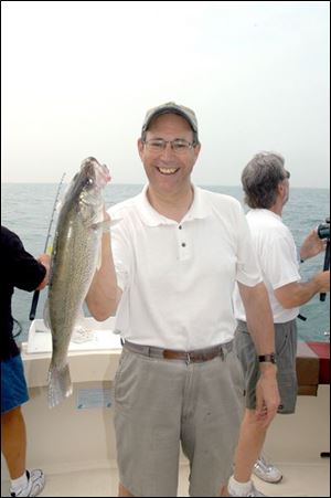Gov. Bob Taft shows off one of the walleye he caught yesterday on Lake Erie.
