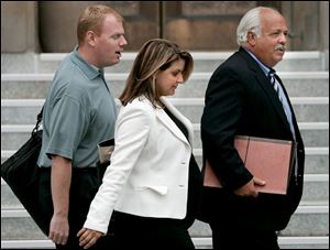 Jessica  Scottie  May, an associate with the Hicks Partners lobbying fi rm, leaves the federal
courthouse with her husband, Brett Buerck, left, and her attorney, who was unidentifi ed.
Columbus-based Hicks Partners is run by Brian Hicks, former chief of staff to Gov. Bob Taft.
