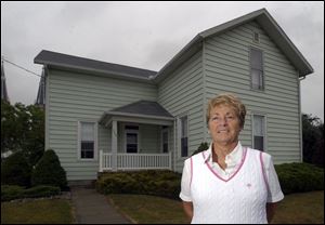 Stephanie Heitmeyer stands in front of the Winkelman home in Ottoville. She was a close friend of Richard Winkelman, the last member of the Winkelman family.
