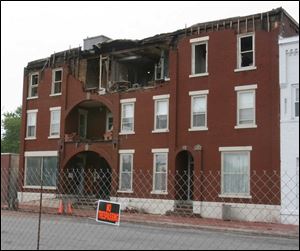The fire-damaged Clermont Manor Apartments will not be razed at least until next week because of a festival in town.