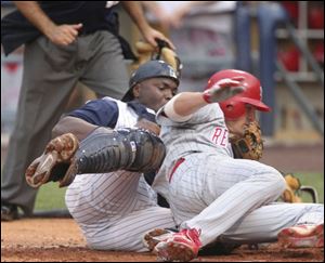 Scranton's Chris Coste slams into Hens catcher Sandy Martinez, who holds onto the ball for the final out in the fourth.