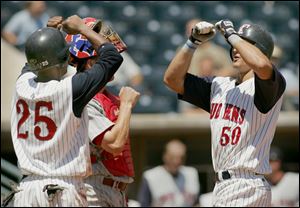 Dewayne Wise (25) greets Brandon Harper (50) at the plate after the Hens catcher belted a home run in the fifth inning yesterday at Fifth Third Field.