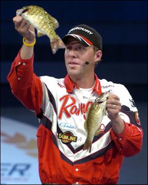 Aaron Martens of Leeds, Ala., holds up part of the catch which enabled him to take the lead in the Bassmaster Classic and stay eligible for today's final competition of the $700,000 event.