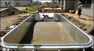 The cement coat goes on to a pool in Perrysburg, one of many constructed in metro Toledo this summer.