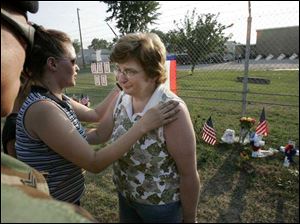 Kathie McPheron is comforted by Amanda Lynn and her husband, Eric, outside the Marine Corps reserve center in
Brook Park, Ohio. 