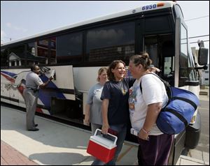 Anna Clark and Ashley Bateson, say good-bye to JoyAnn Powell, who is taking the nationwide bus service to Asheville, N.C.