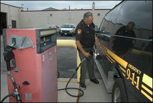 Deputy David Lindhorst refuels at the Lucas County garage. Many area governments are trying to address rising gas prices.