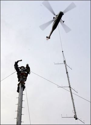 The final piece of a 6,000-pound offshore wind tower is lowered into place in Lake Erie near downtown Cleveland.