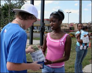 Kyle Ottney, 14, left, of Oregon gives $14 to Toledoan Verna Wilson for the McCrary family, with whom Ms. Wilson was trapped in New Orleans. The McCrary family is staying in East Toledo.
