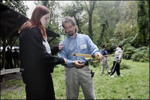 Karl Koch shows Laura Grant how to use a bow and arrow as part of the four-day Warrior School program.

