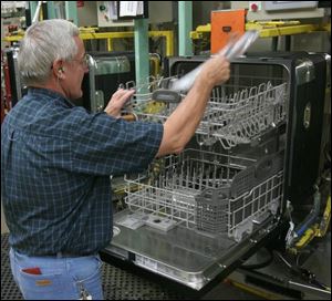 Jack Glick places an instruction manual into a finished dishwasher during final assembly at Whirlpool's Findlay operation. 