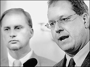 Sen. Marc Dann, right,
speaks during a press conference
yesterday with Rep. William Healy
II, left.